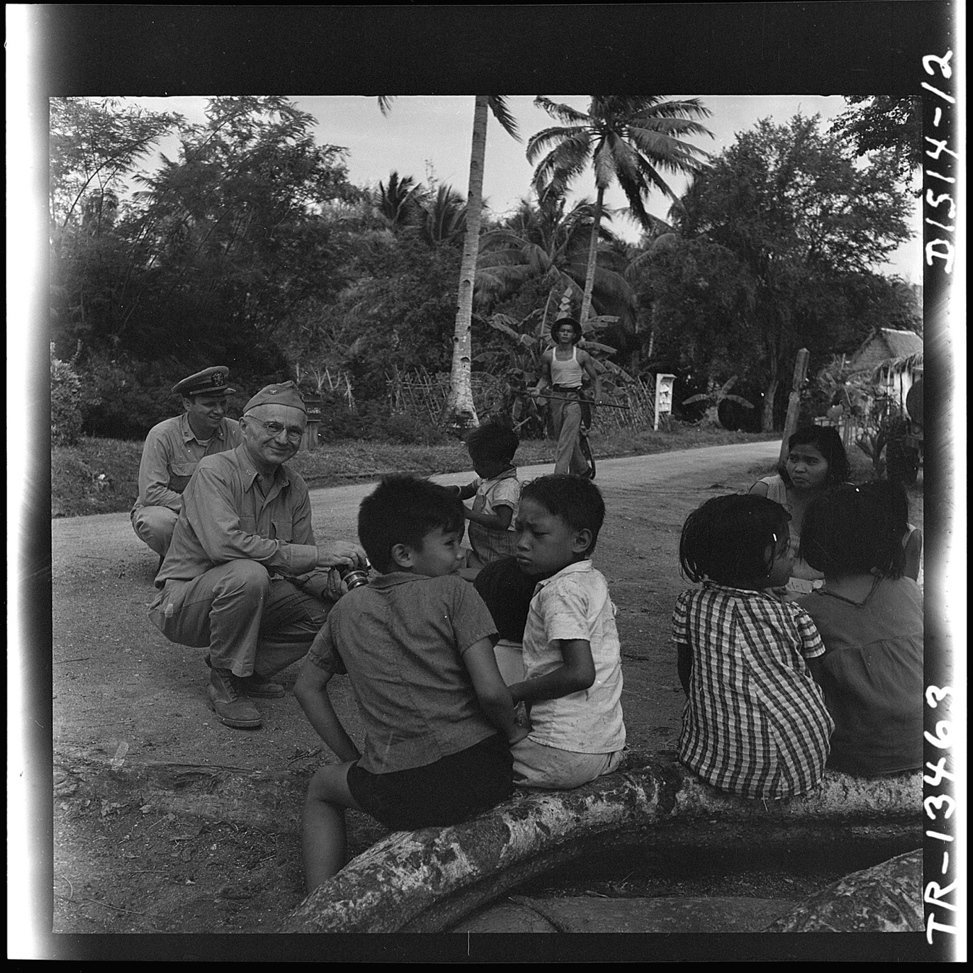 Captain E. J. Steichen photographing children on Guam Island, circa 1945